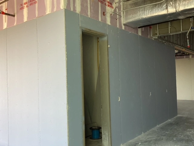 Unfinished wall with a narrow doorway in a construction site.